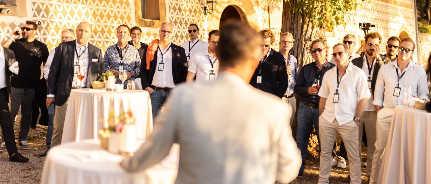 Mitglieder stehen im Innenhof und hören einem Sprecher zu, Fast Track Mallorca 2025